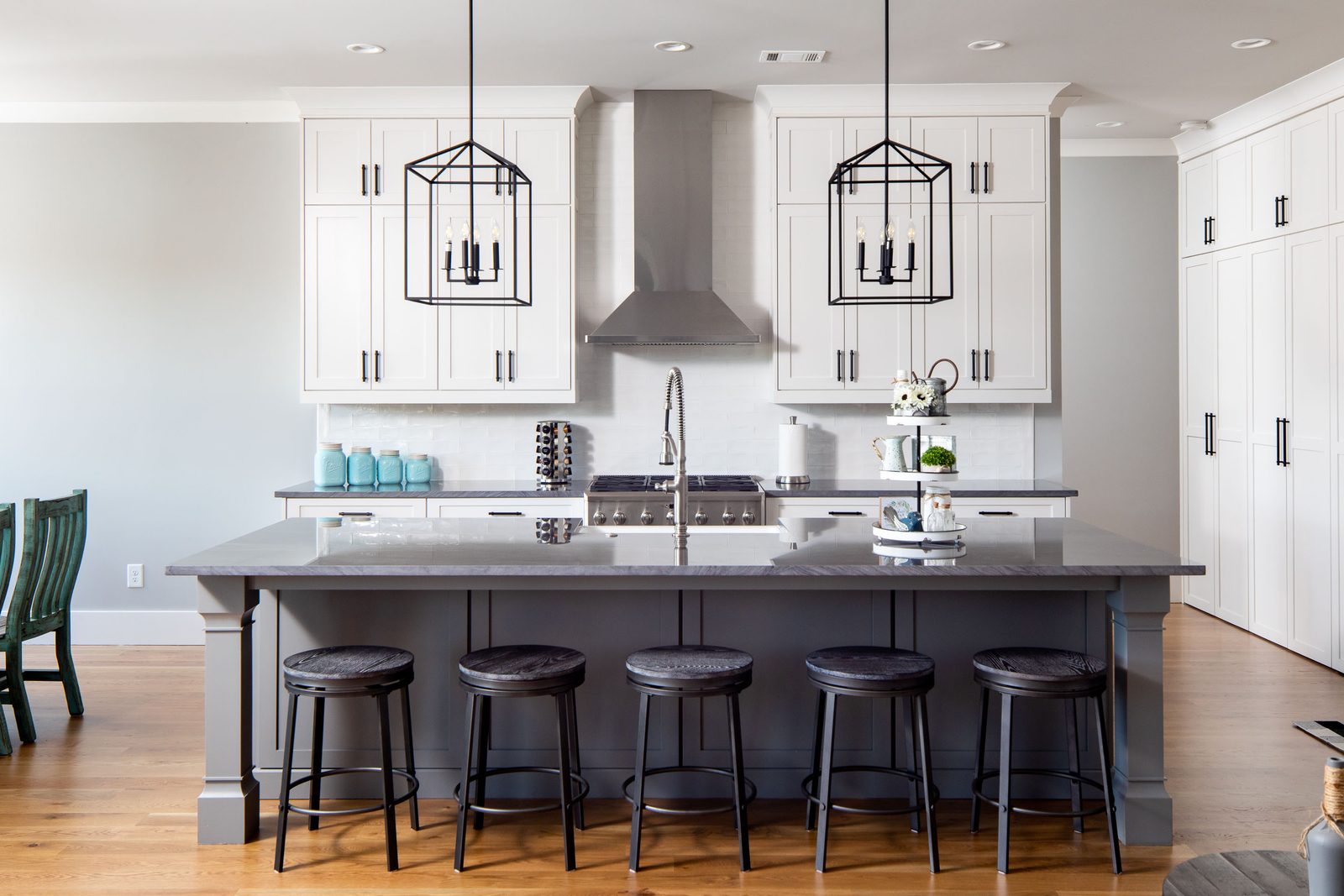 Kitchen with grey island, white cabinetry and stainless hood — Glausier, custom home built by Ironwood Construction Group