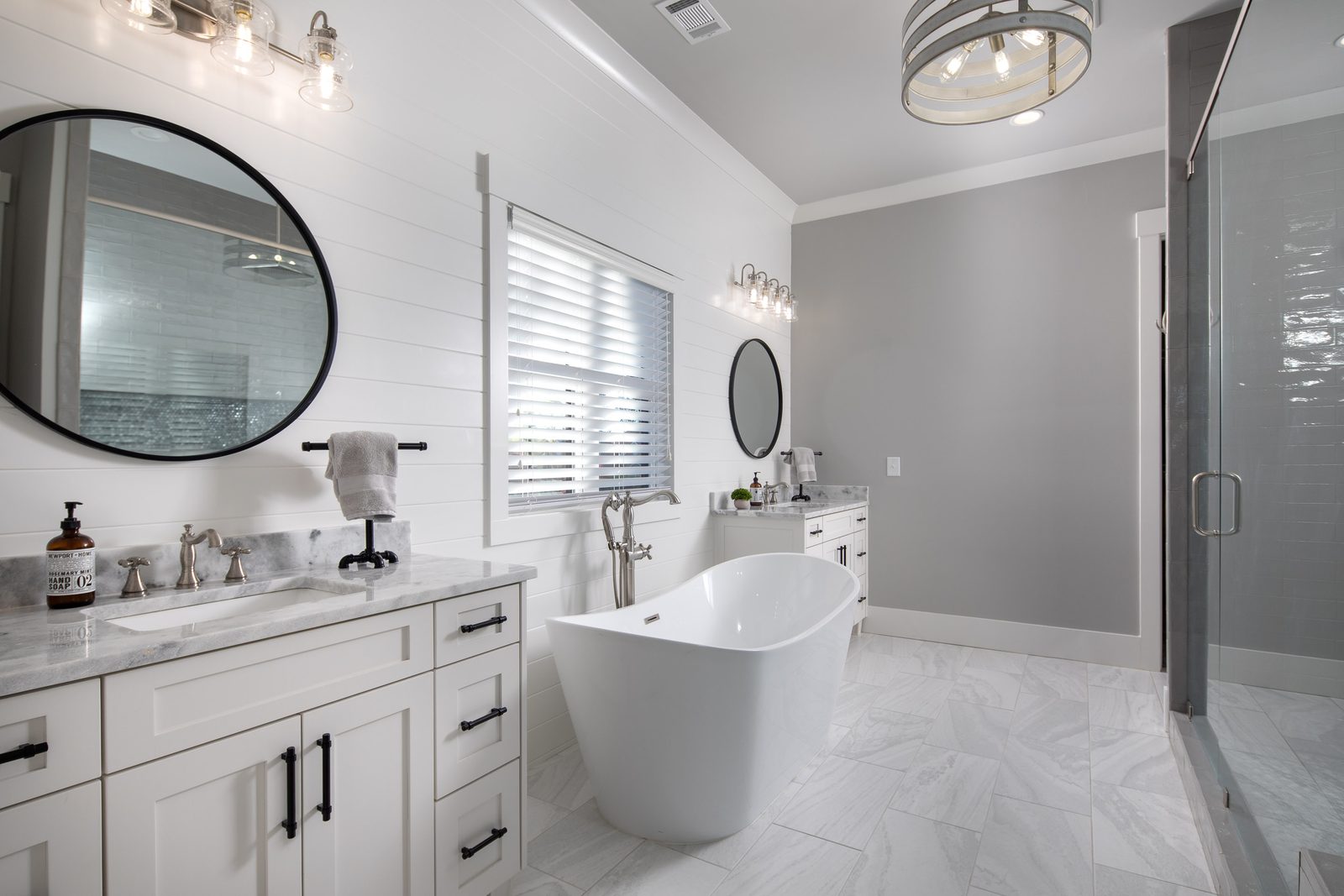 Primary bath with freestanding tub and double vanity — Glausier, custom home built by Ironwood Construction Group
