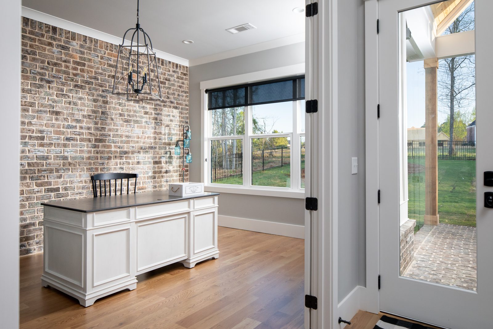 Kitchen island standing against the exposed brick wall — Spring 2020 Custom Home, custom home built by Ironwood Construction Group